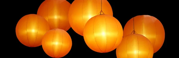 Lámparas de globo de colores cálidos aislados sobre fondo negro —  Fotos de Stock
