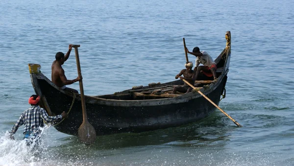 Les pêcheurs tirent leur filet de pêche dans un travail combiné hors de la mer — Photo