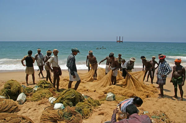 Les pêcheurs tirent leur filet de pêche dans un travail combiné hors de la mer — Photo