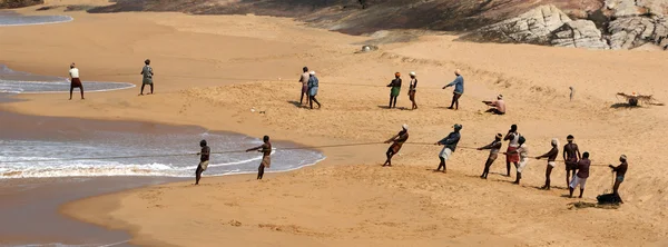 Fishermen are pulling their fishing net in combined work out of the sea — Stock Photo, Image