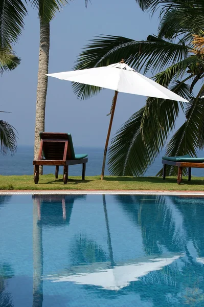 Palmeras de coco reflejándose en la piscina de agua cerca del océano — Foto de Stock