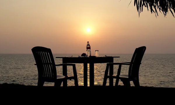 Tischrestaurant am Strand bei Sonnenuntergang — Stockfoto