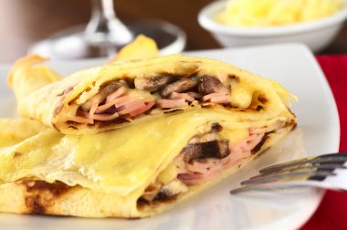 Crepes filled with ham, cheese and mushroom clipart