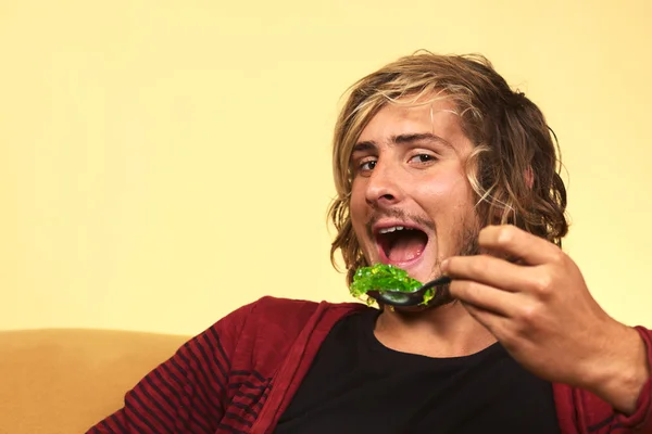Młody człowiek jedzenie zielonej galaretki — Zdjęcie stockowe