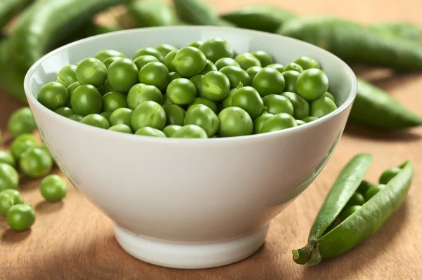 Färska råa gröna ärter i vit skål — Stockfoto