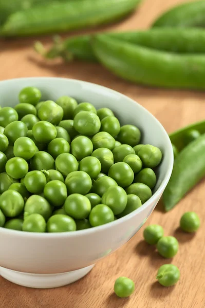 Färska råa gröna ärter i vit skål — Stockfoto