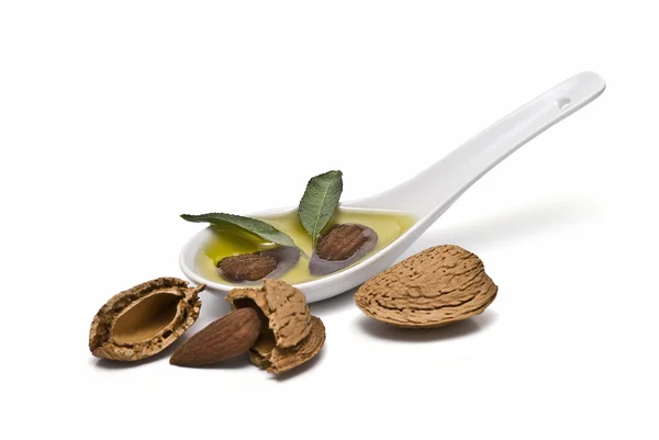 stock image Almond and a spoon with its oil.