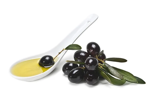 Łyżkę oliwy i oliwki czarne. — Zdjęcie stockowe
