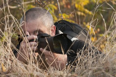 Photographer pointing his camera. clipart