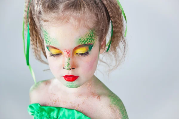 Stock image The young girl painted like a dragon