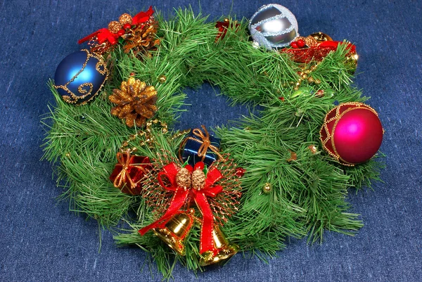 Trevlig xmas dekorationer: rött, silver och blått klot, gyllene klockor med rött band och grön jul krans över blå — Stockfoto