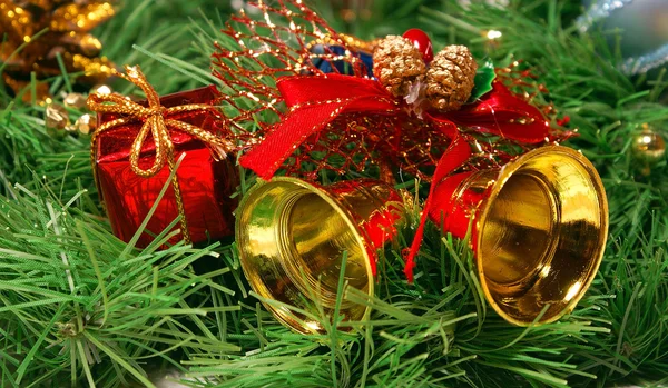 Campanas de oro contra la rama del árbol de Navidad —  Fotos de Stock