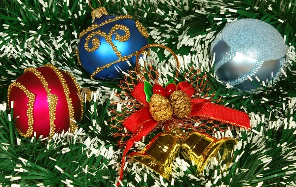 Nice Xmas decorations: red and blue spheres, golden bells and garland over white — Stock Photo, Image