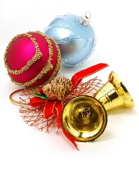 Nice Xmas decorations: red and blue spheres, golden bells and garland over white — Stock Photo, Image