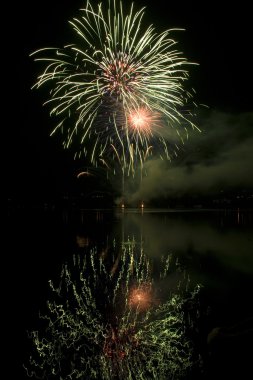 Colorful fireworks on black sky background with water reflection clipart