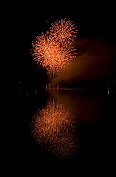 Colorful fireworks on the black sky background and water reflect — Stock Photo, Image