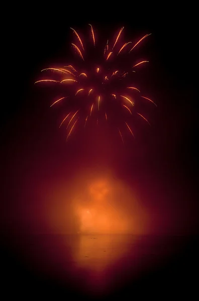 Coloridos fuegos artificiales en el fondo del cielo negro y el agua reflejan — Foto de Stock