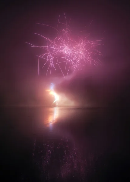 Красочные фейерверки на фоне черного неба с отражением воды — стоковое фото