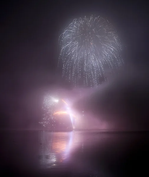 Buntes Feuerwerk auf schwarzem Himmel Hintergrund mit Wasserreflexion — Stockfoto