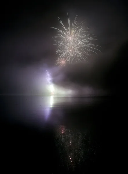 カラフルな花火は黒い空の背景と水に反映します。 — ストック写真