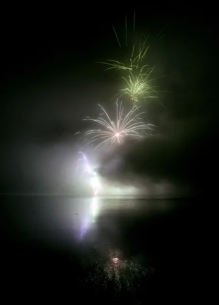炫彩焰火与水中倒影的黑色的天空背景上 — 图库照片