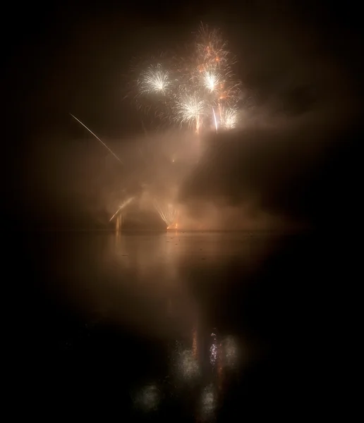 Fogos de artifício coloridos no fundo do céu preto com reflexão de água — Fotografia de Stock