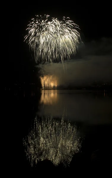 カラフルな花火は水の反射と黒の空を背景に — ストック写真