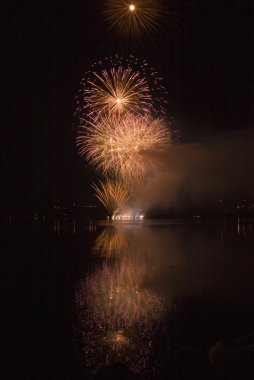 Colorful fireworks on black sky background with water reflection clipart