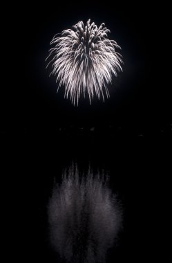 Clear white fireworks on black sky background with water reflect clipart