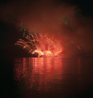 Colorful fireworks on black sky background with water reflection clipart