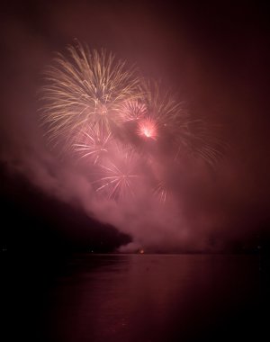 Colorful fireworks on black sky background with water reflection clipart