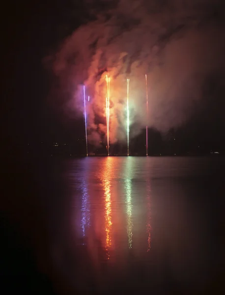Kleurrijke vuurwerk op zwarte lucht achtergrond met water reflectie — Stockfoto