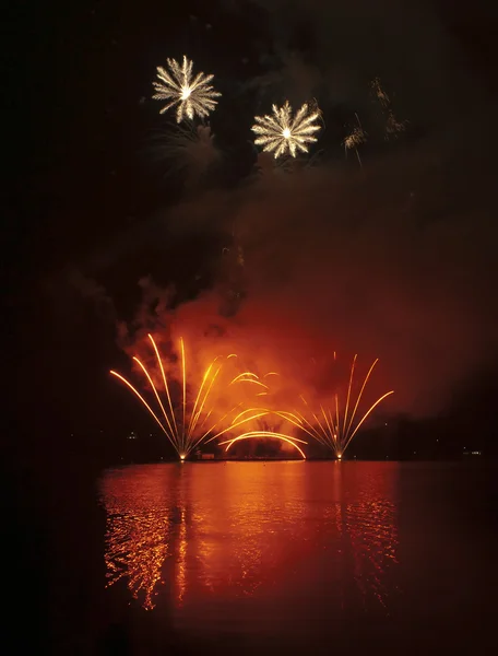 カラフルな花火は水の反射と黒の空を背景に — ストック写真