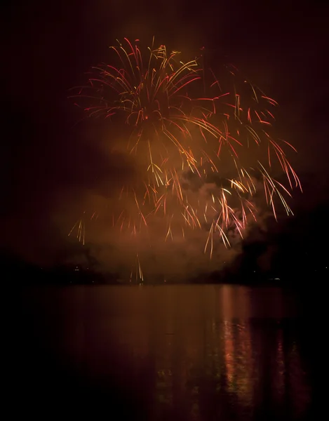 Красочные фейерверки на фоне черного неба с отражением воды — стоковое фото