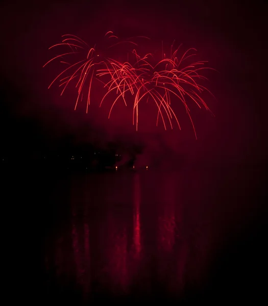Fogos de artifício coloridos no fundo do céu preto com reflexão de água — Fotografia de Stock