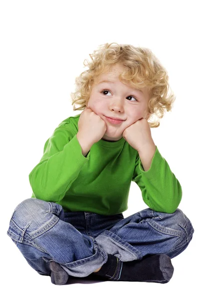 Marzycielski chłopiec siedzi na podłodze — Zdjęcie stockowe