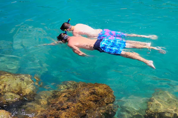 stock image Two tourists snorkeling in clear sea water.