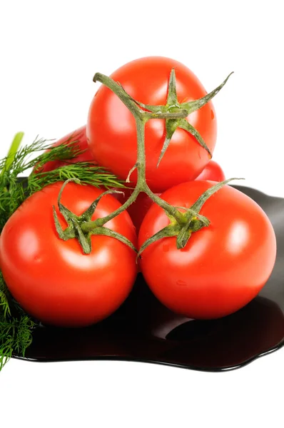Tomatoes on a black plate — Stock Photo, Image