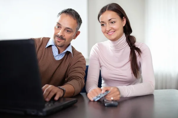 Vacker kvinna sitter med en man som använder bärbar dator — Stockfoto