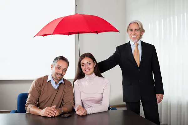 Agent providing insurance cover to a young couple — Stock Photo, Image