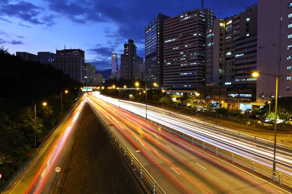 Senderos ligeros en la ciudad moderna por la noche — Foto de Stock