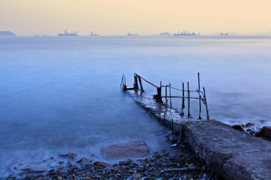 Old pier at sunset clipart