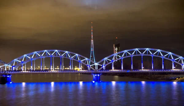 stock image Railway bridge and a television tower at night in Riga