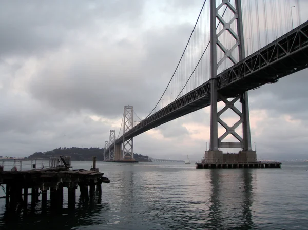 Staré molo a Bay Bridge na mlžný den — Stock fotografie