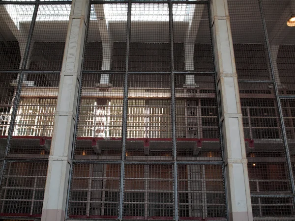Cage of bars with cell blocks behind them — Stock Photo, Image