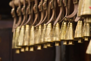 Old brass village bells hanging on a row clipart