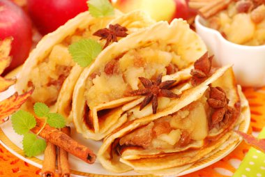 Pancakes with stewed apples ,raisins and cinnamon clipart