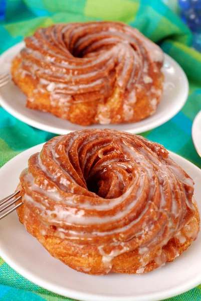 Twee gedraaide donuts met suikerglazuur — Stockfoto