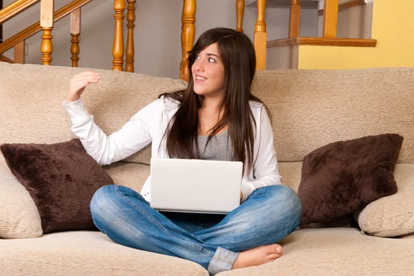 Молодая женщина с ноутбуком портативный компьютер сидит на диване — стоковое фото