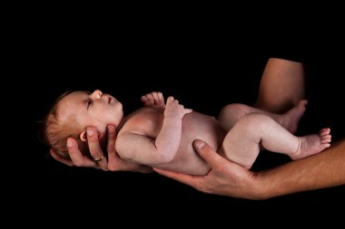 Infant girl on fathers arms isolated on black clipart